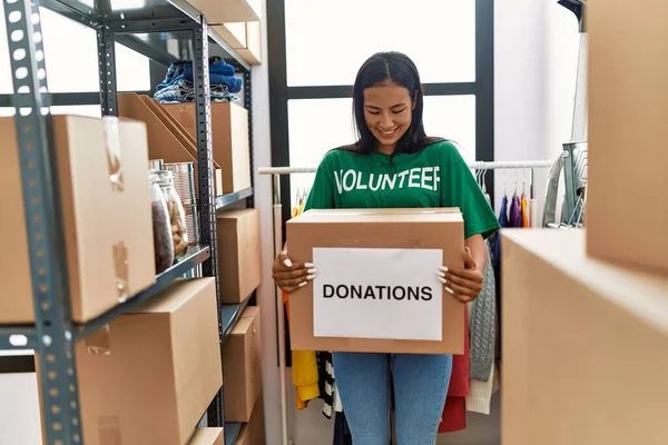 Young Latin Woman Wearing Volunteer Uniform Holding Donations Cardboard Box — Stock Photo, Image