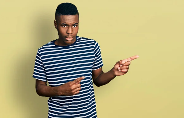 若いアフリカ系アメリカ人の男性は 問題のために動揺を眉をひそめて 懐疑的で緊張した側面を指差しています 否定的な人 — ストック写真