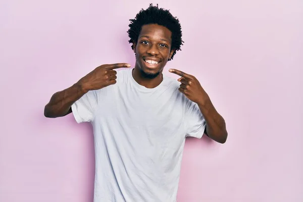 年轻的非洲裔美国人 身穿休闲的白色T恤 笑容满面 手指手画脚 牙齿健康概念 — 图库照片