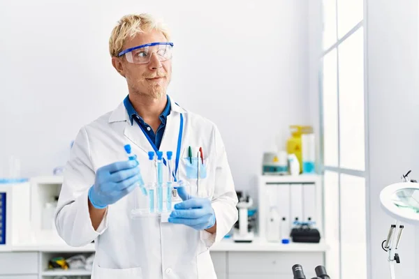 Młody Biały Mężczyzna Noszący Mundur Naukowca Trzymający Probówkę Laboratorium — Zdjęcie stockowe