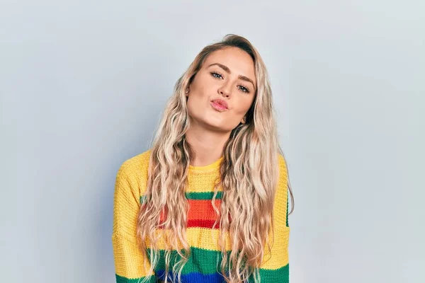 Piękna Młoda Blondynka Ubrana Kolorowy Sweter Patrząca Kamerę Dmuchająca Pocałunek — Zdjęcie stockowe