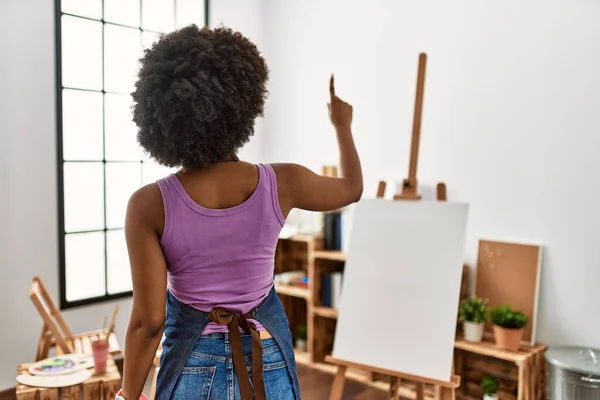 Junge Afroamerikanerin Mit Afrohaaren Posiert Kunststudio Rückwärts Und Zeigt Mit — Stockfoto