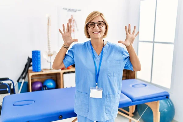 Middle Age Blonde Woman Working Pain Recovery Clinic Showing Pointing — Stock Photo, Image
