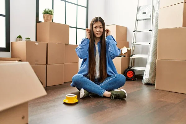 Joven Chica China Sentada Suelo Casa Nueva Cubriendo Las Orejas —  Fotos de Stock