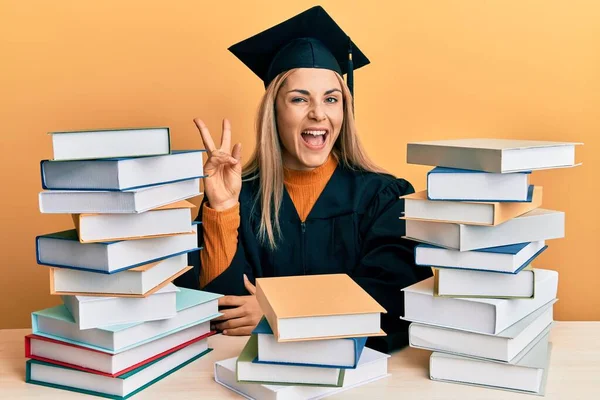 Junge Kaukasische Frau Abschlusszeremoniengewand Sitzt Auf Dem Tisch Und Lächelt — Stockfoto