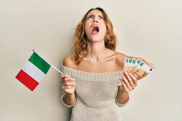 Mujer Caucásica Joven Sosteniendo Bandera Italia Billetes Euros Enojado Loco —  Fotos de Stock