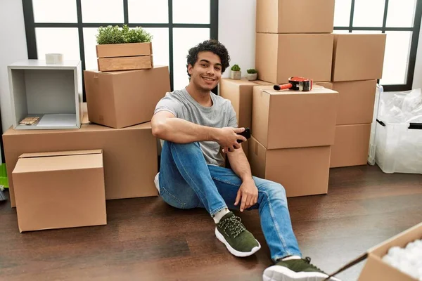 Jovem Hispânico Sorrindo Feliz Sentado Chão Uma Nova Casa — Fotografia de Stock