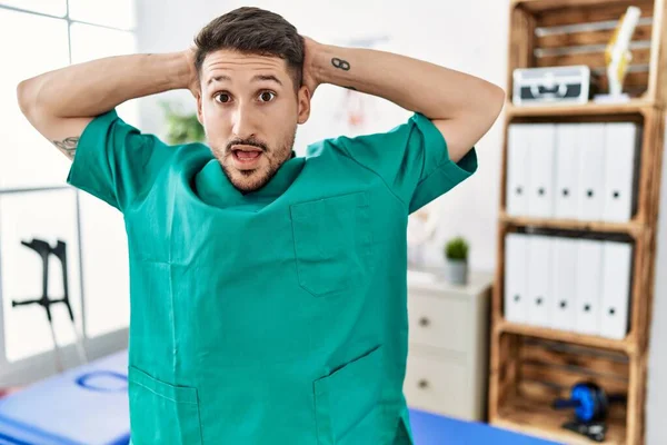 Jovem Fisioterapeuta Homem Trabalhando Clínica Recuperação Dor Louco Assustado Com — Fotografia de Stock