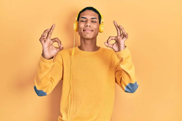 Joven Afroamericano Chico Escuchando Música Usando Auriculares Relajado Sonriendo Con — Foto de Stock