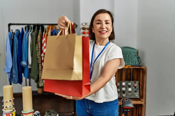 中世のヒスパニック女性がショッピングバッグを持って働いています小売店 — ストック写真