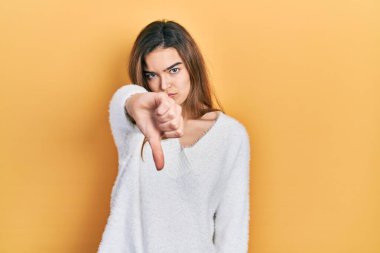 Kafkasyalı genç bir kız gündelik kıyafetler giyiyor mutsuz ve kızgın görünüyor reddedildiğini gösteriyor ve olumsuz bir hareket yapıyor. kötü ifade. 