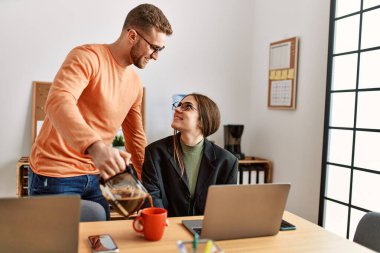 Ofiste çalışan ve kahve içen iki beyaz iş adamı..