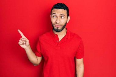 Sakallı İspanyol bir adam parmaklarını yan tarafa uzatıp gülümsüyor, yan tarafa bakıyor ve düşünüyor.. 