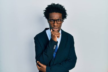 Genç Afro-Amerikalı bir adam iş elbisesi ve kravat takmış, şaşkın ve alaycı görünüyor, ağzı açık kalınca şaşırıyor. 