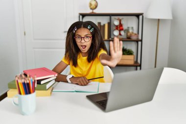 Genç Afro-Amerikalı kız evde ödev yapıyor. El hareketlerini, kızgın ve hayal kırıklığına uğramış ifadesini durduruyor. 