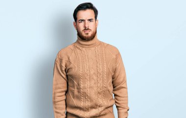 Gündelik kıyafetler giyen, kuşkucu ve gergin genç İspanyol bir adam sorun yüzünden surat asıyor. negatif kişi. 