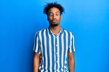 Sakallı, sıradan çizgili tişörtlü, dudağıyla balık suratı yapan, çılgın ve komik bir jest yapan Afrikalı genç bir Amerikalı. Komik ifade. 
