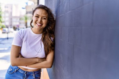 Çekici ve güzel İspanyol kadın güneşli bir havada mutlu gülümsüyor. Güzel esmer kız pozitif gülüşü olan Şehre kendinden emin bakan