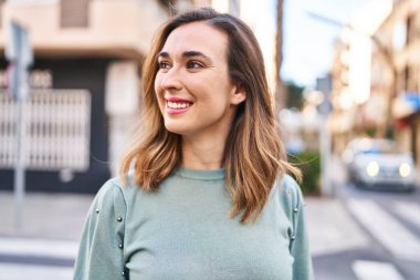 Sokakta kendinden emin gülümseyen genç bir kadın