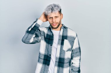 Modern boyalı saçlı, gündelik gömlek giyen İspanyol genç adam soru sorup şaşırıyor. Şüpheyle kararsız, kafa kafaya düşünerek. Düşünceli kavram. 