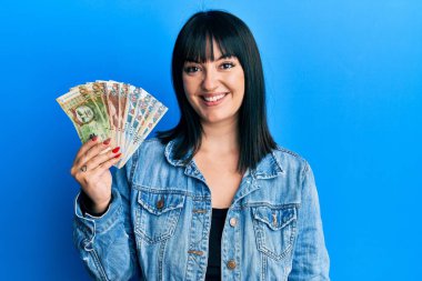 Genç İspanyol kadın elinde Peru sol banknotları tutuyor. Pozitif ve mutlu görünüyor. Kendine güvenen bir gülümsemeyle dişlerini gösteriyor. 