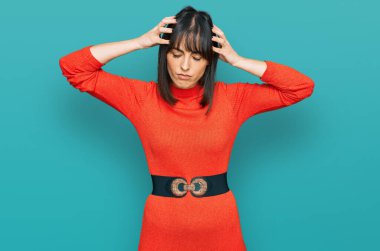 Genç İspanyol kadın gündelik kıyafetler giyiyor. Baş ağrısı, çaresiz ve stresli. Ağrı ve migren yüzünden. Eller başının üstünde.. 