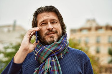 Kasabada konuşan orta yaşlı yakışıklı adam.