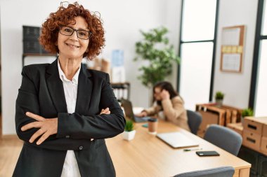 Kapsayıcı takım çalışmasında çalışan olgun bir kadın. Ofiste çalışan iki kadın grubu..