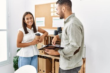 İki Latin iş adamı panoya yazı yazıp ofiste kahve içiyorlar..