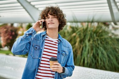 Genç İspanyol adam şehirde telefonla konuşuyor.