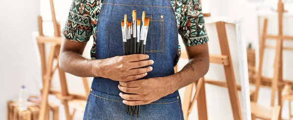 若いアフリカ系アメリカ人のアーティストがアートスタジオで絵筆を持っている — ストック写真