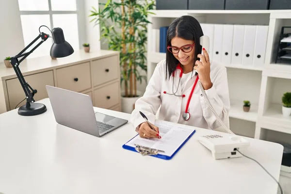 Jovem Latina Vestindo Uniforme Médico Falando Telefone Clínica — Fotografia de Stock