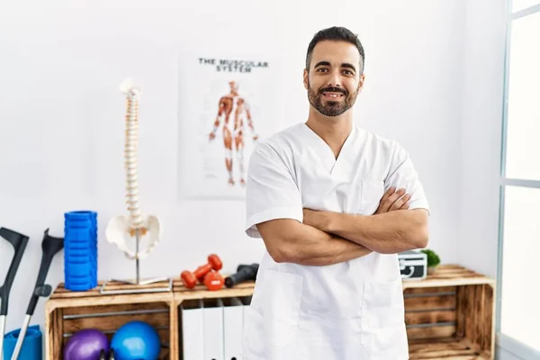 Junger Hispanischer Mann Physiotherapeutenuniform Steht Mit Verschränkten Armen Klinik — Stockfoto