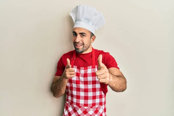 Jovem Hispânico Vestindo Uniforme Padeiro Apontando Dedos Para Câmera Com — Fotografia de Stock