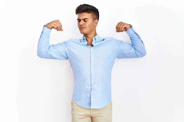 ビジネスシャツを着た若いヒスパニック系の男性は 腕の筋肉を誇りに笑顔を見せて孤立した背景に立っている フィットネスのコンセプト — ストック写真
