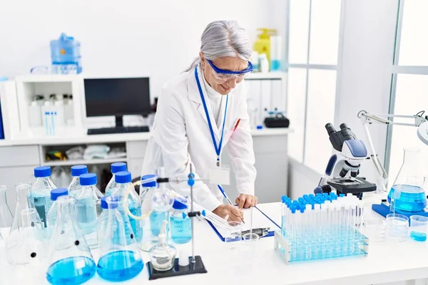 Middle Age Grey Haired Woman Wearing Scientist Uniform Writing Clipboard — Stock Photo, Image