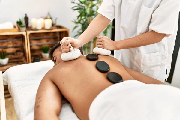 Jovem Hispânico Relaxado Tendo Massagem Nas Costas Usando Pedras Pretas — Fotografia de Stock