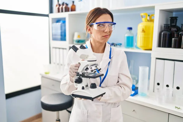 Jovem Morena Trabalhando Laboratório Cientistas Com Microscópio Sorrindo Olhando Para — Fotografia de Stock