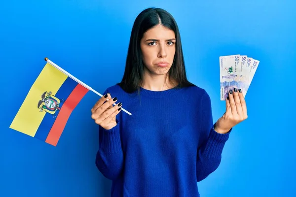 年轻的惊慌失措的女人拿着科洛姆比亚国旗和科洛姆比亚比索钞票忧心忡忡 哭哭啼啼 悲伤的表情 — 图库照片