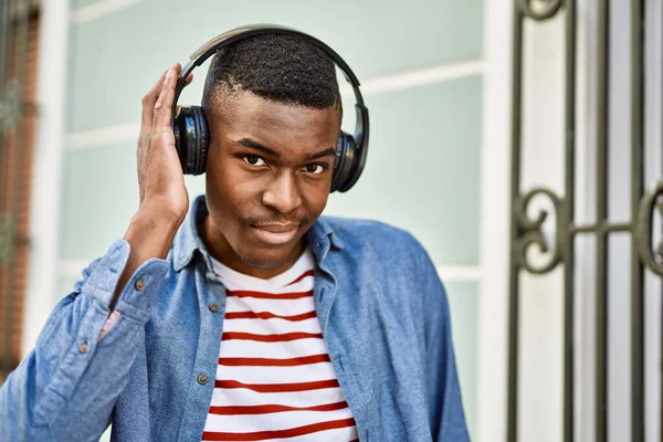 年轻的非洲裔美国人在城里用耳机开心地微笑着 — 图库照片
