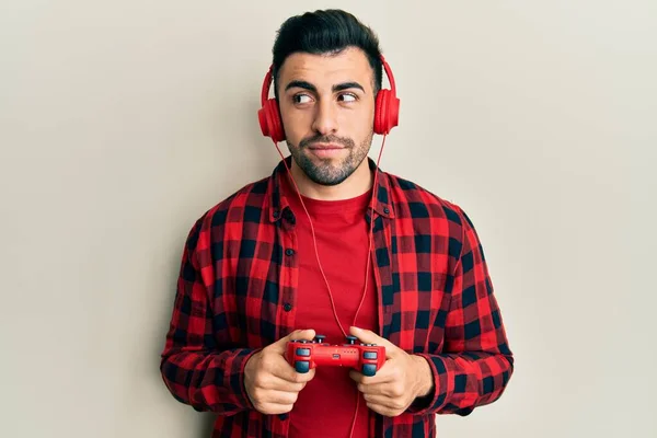 Νεαρός Ισπανός Που Παίζει Βιντεοπαιχνίδι Κρατώντας Χειριστήριο Χαμογελώντας Κοιτώντας Στο — Φωτογραφία Αρχείου