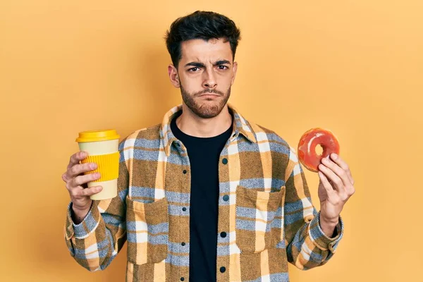 Νεαρός Ισπανός Τρώει Ντόνατ Και Πίνει Καφέ Σκεπτικός Και Νευρικός — Φωτογραφία Αρχείου