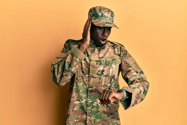 若いアフリカ系アメリカ人の男が軍の制服を着て時計を見て心配し遅くなるのを恐れて — ストック写真