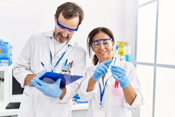 Middle Age Man Woman Partners Wearing Scientist Uniform Writing Clipboard — Stock Photo, Image