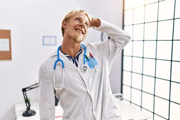 Jonge Blonde Man Doktersuniform Stethoscoop Kliniek Glimlachend Vol Zelfvertrouwen Haar — Stockfoto