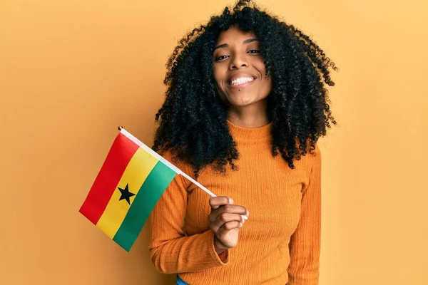 Африканская Американка Афроволосами Держащая Флаг Ганы Выглядит Позитивно Счастливо Стоя — стоковое фото