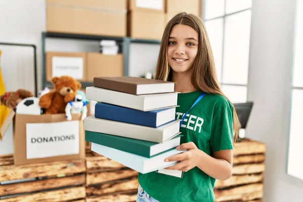 Schattig Meisje Draagt Vrijwilligersuniform Met Boeken Een Liefdadigheidscentrum — Stockfoto