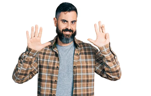 自信と幸せ笑みを浮かべている間 髭を生やしたヒスパニック系の男はカジュアルなシャツを着て表示され 指番号9で指摘 — ストック写真
