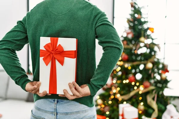 Joven Pelirrojo Sosteniendo Regalo Espalda Pie Junto Árbol Navidad Casa —  Fotos de Stock