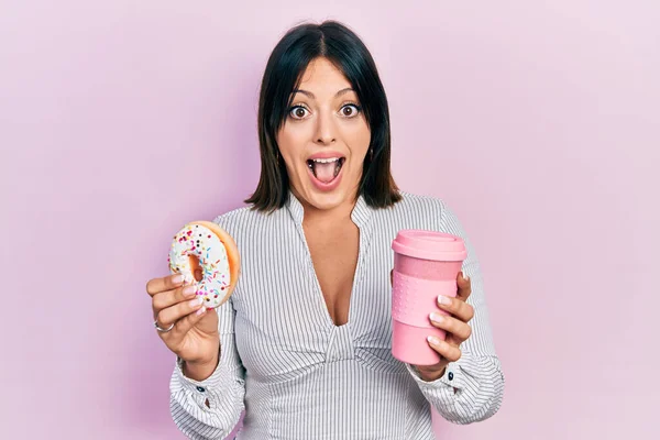 Jovem Hispânica Comendo Donut Bebendo Café Comemorando Louco Surpreso Com — Fotografia de Stock